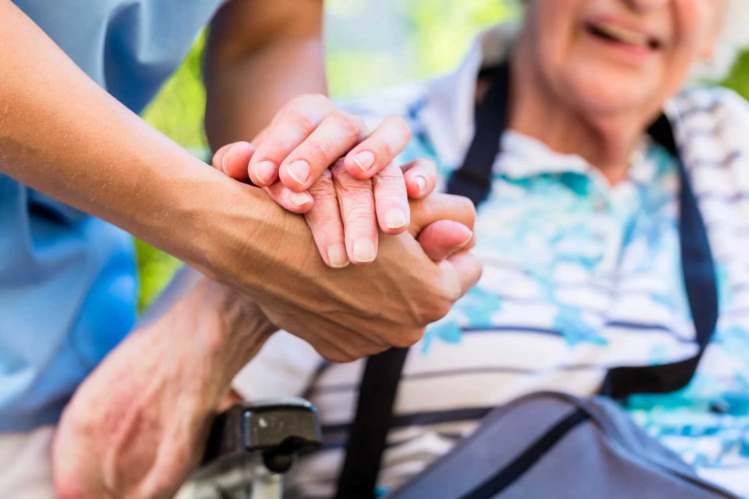 Krankenschwester tröstet ältere Frau, die ihre Hand hält